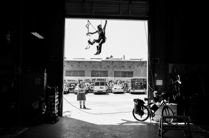 A climber uses lanyards as a means for progression while aid climbing during a training.